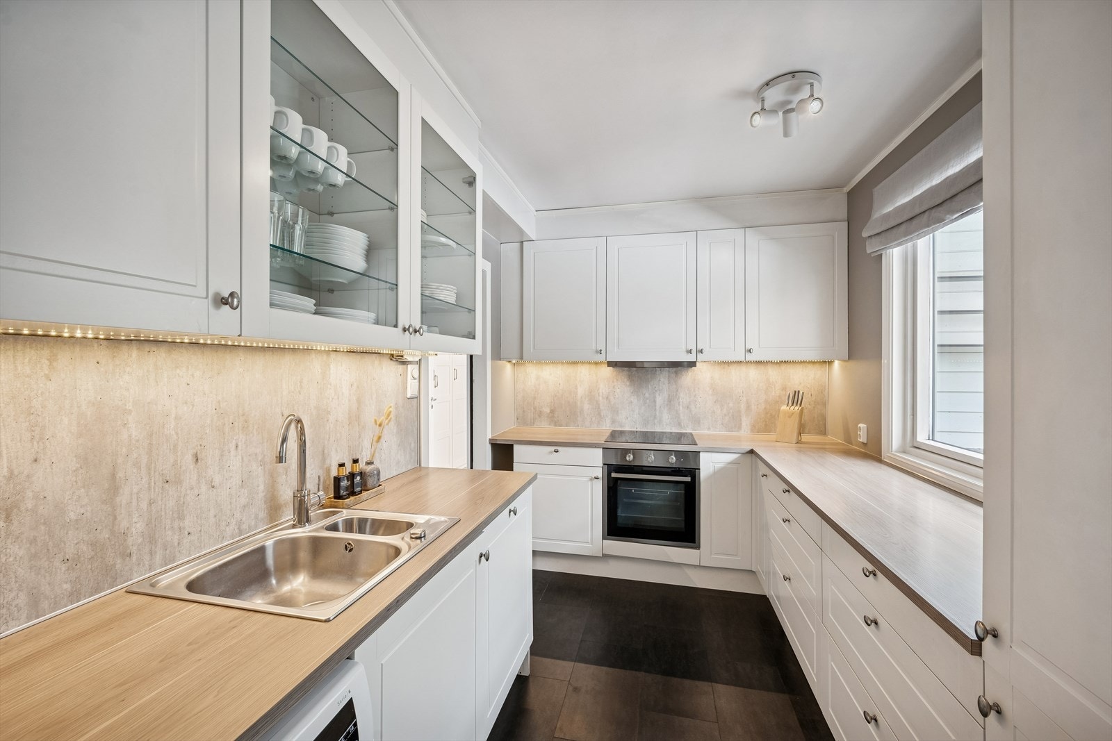 Kjøkkenet har integrert kjøl/fryseskap, oppvaskmaskin, vaskemaskin, induksjonstopp, stekeovn og vannstoppsystem Galleribilde