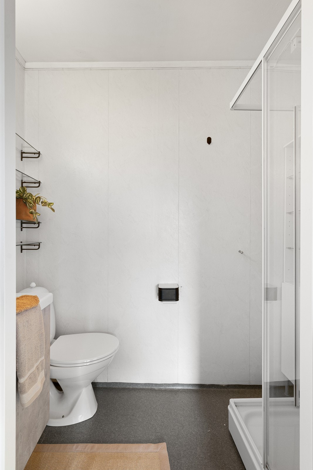 Badet er innredet med toalett, vask i servantskap og dusjkabinett. Galleribilde