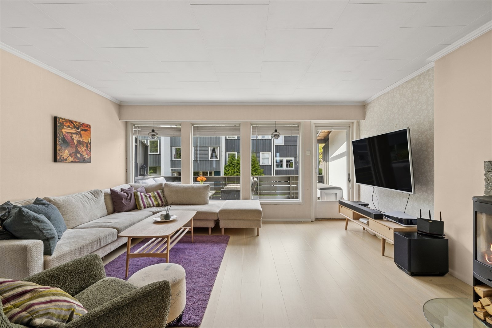 Vide vindusflater gir godt med naturlig lys til stuen, samt en luftig følelse til rommet. Galleribilde