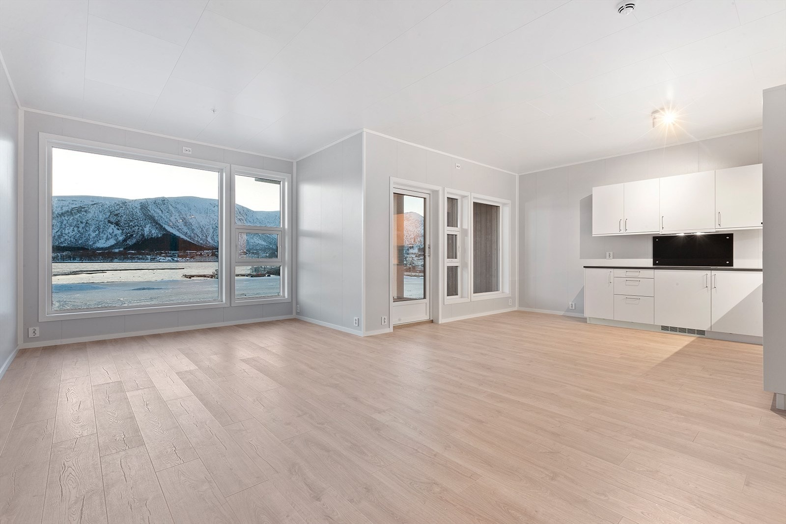 Det er flere store vinduer som gir godt og naturlig innlys. Her er det også direkte utgang til boligens balkong. Galleribilde