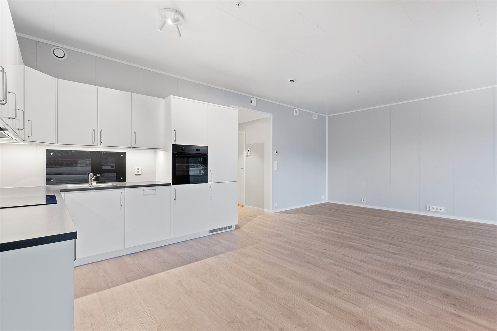 Kjøkkenet er av type "Nordsjø" fra Drømmekjøkken med hvite slette fronter. Innredningen har godt med skapplass og integrerte hvitevarer fra Electrolux følger med: Koketopp (induksjon), stekeovn med mulitfunksjon, kjøl/ frys og oppvaskmaskin. Galleribilde