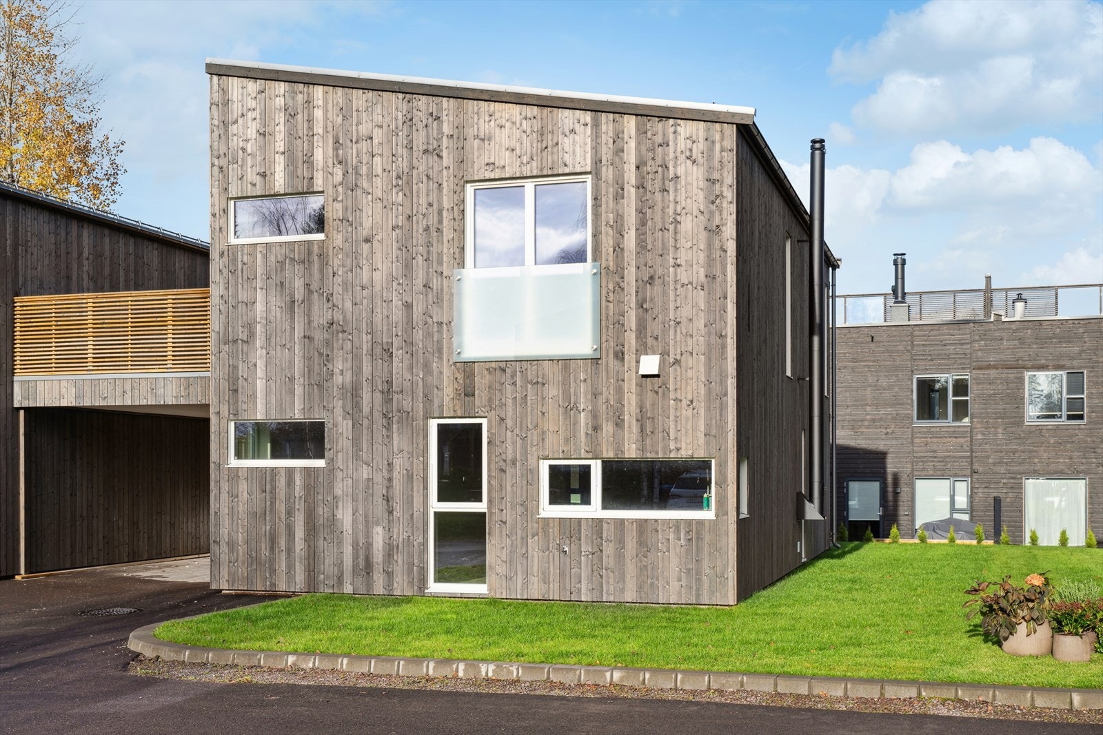 Carport ved inngangspartiet og parkering i gårdsplass. Det er også felles gjesteparkering på fellesarealet. Galleribilde