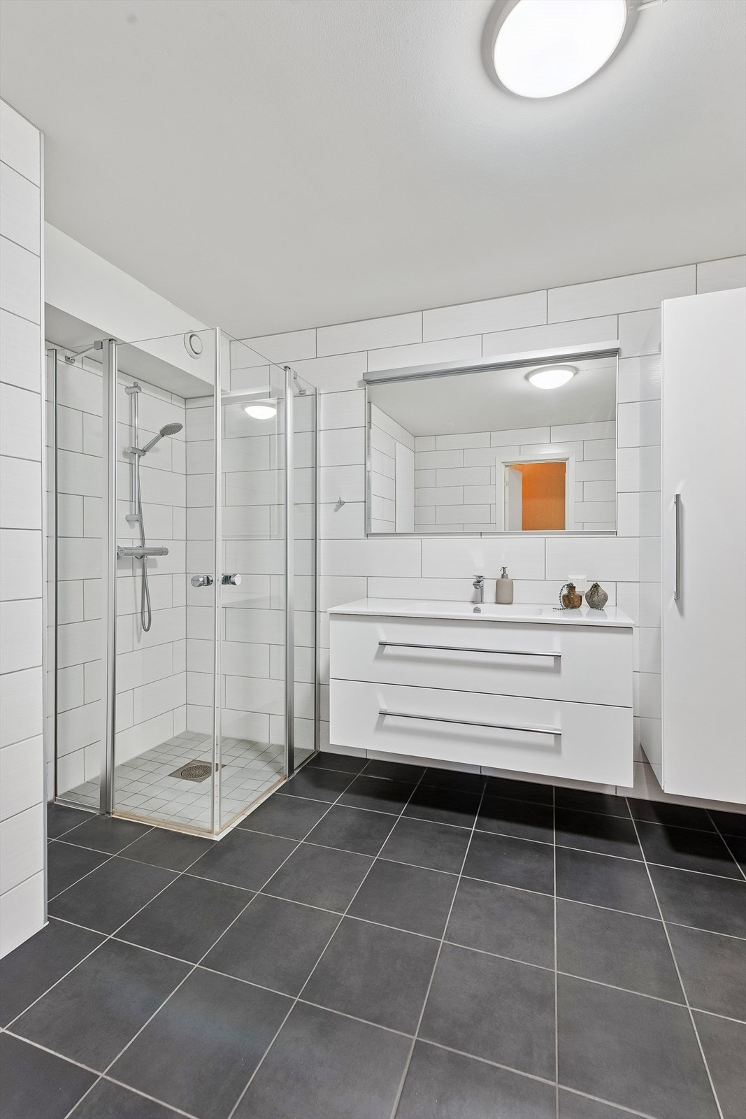 Her er det dusjhjørne med innfellbare vegger og vegghengt dusjbatteri. Galleribilde