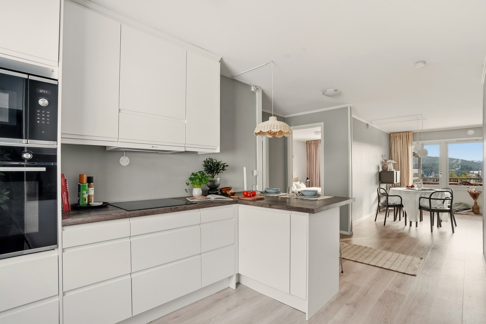 En åpen løsning sammen med lyse overflater og store vinduer gir leiligheten en luftig og romslig følelse Galleribilde