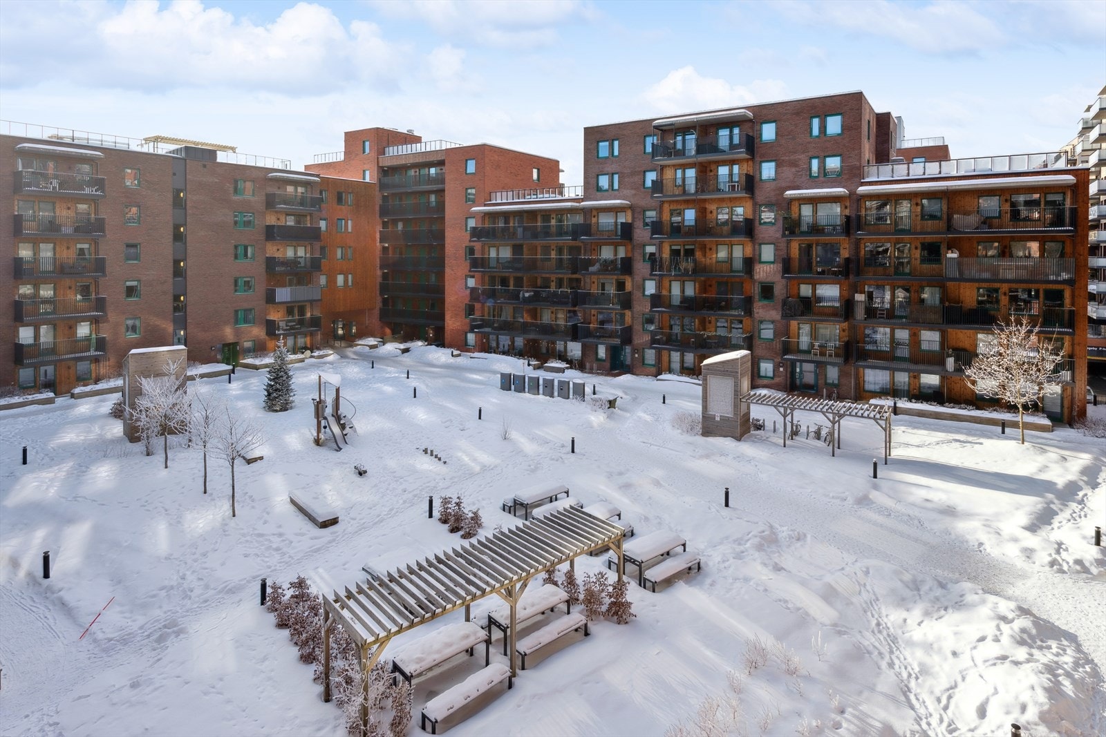 Utsikt fra balkongen til et flott, parkmessig fellesområde - vinterbilde. Galleribilde