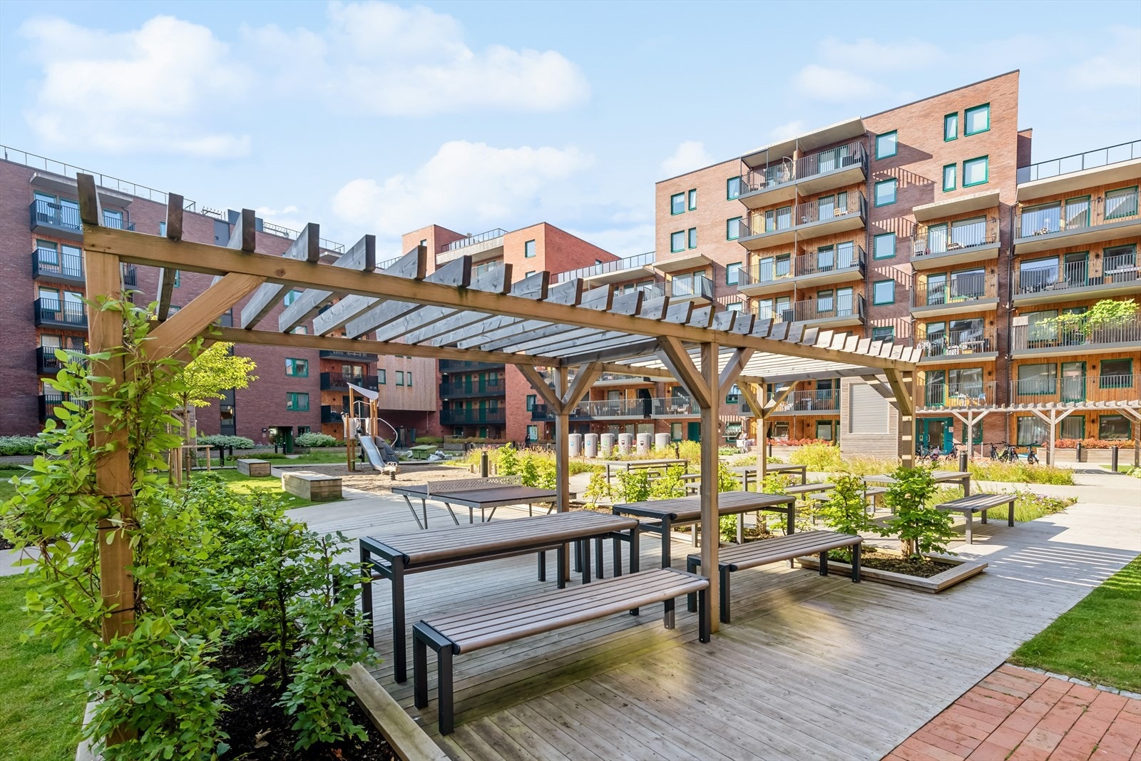 Sommeridyll - Et vakkert og velstelt fellesområde med lekeplass for barn, grillplass og mye beplantning. Galleribilde