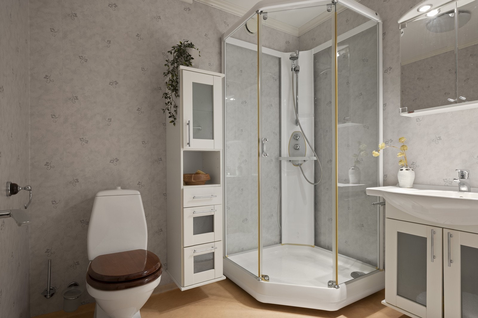 Badet er utstyrt med dusjkabinett, servant og toalett, samt elektrisk gulvvarme. Galleribilde