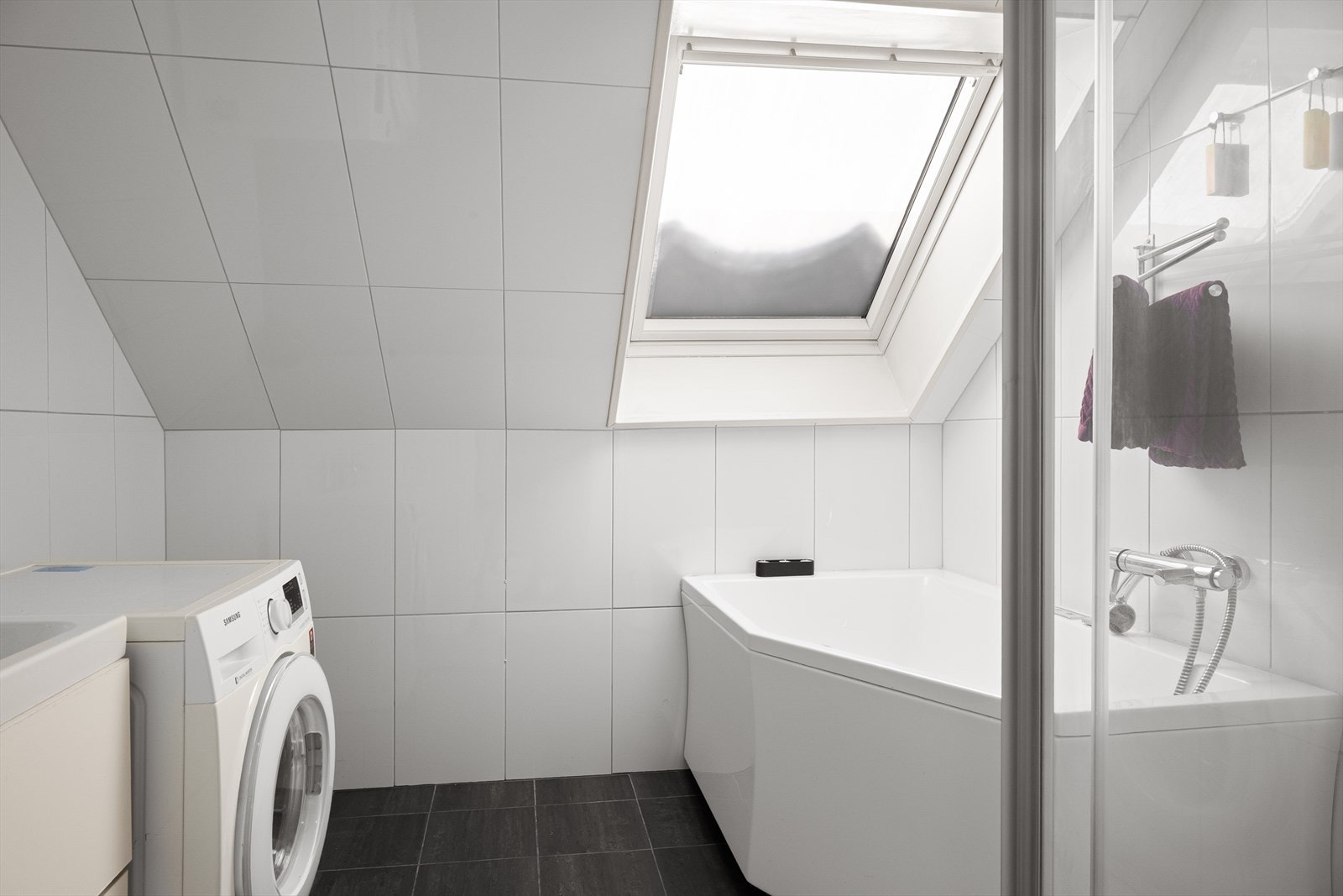 Helfliset bad med varmekabler, dusjkabinett og boblebad under takvindu Galleribilde