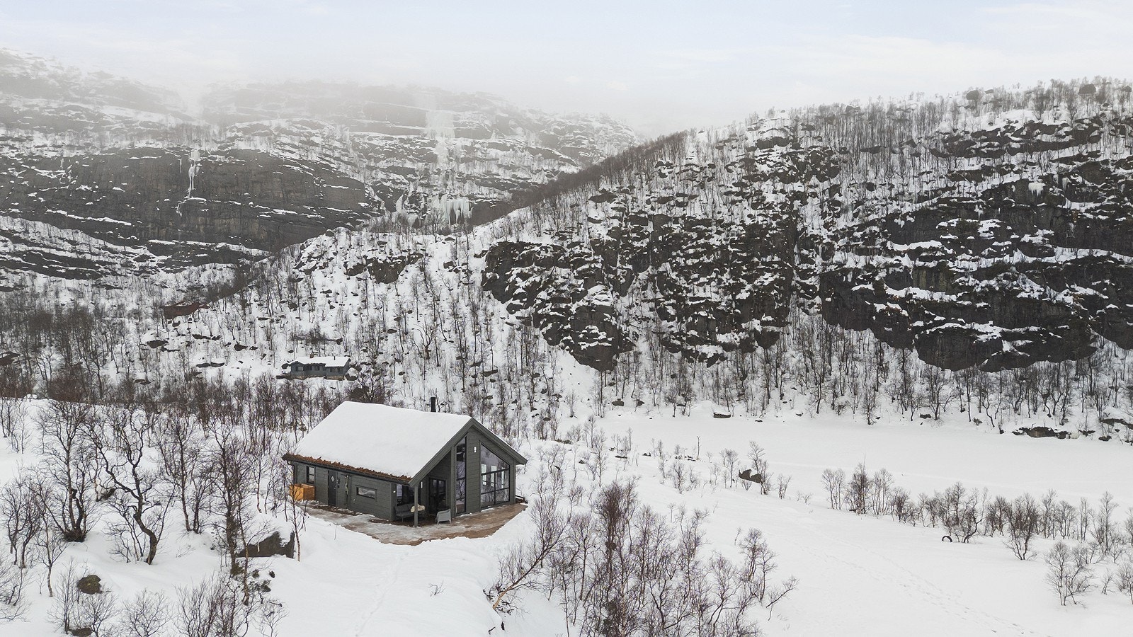 Hytta ligger innerst i en blindvei, helt uten trafikkstøy og innsyn, og bilene parkeres på en felles parkeringsplass. Galleribilde