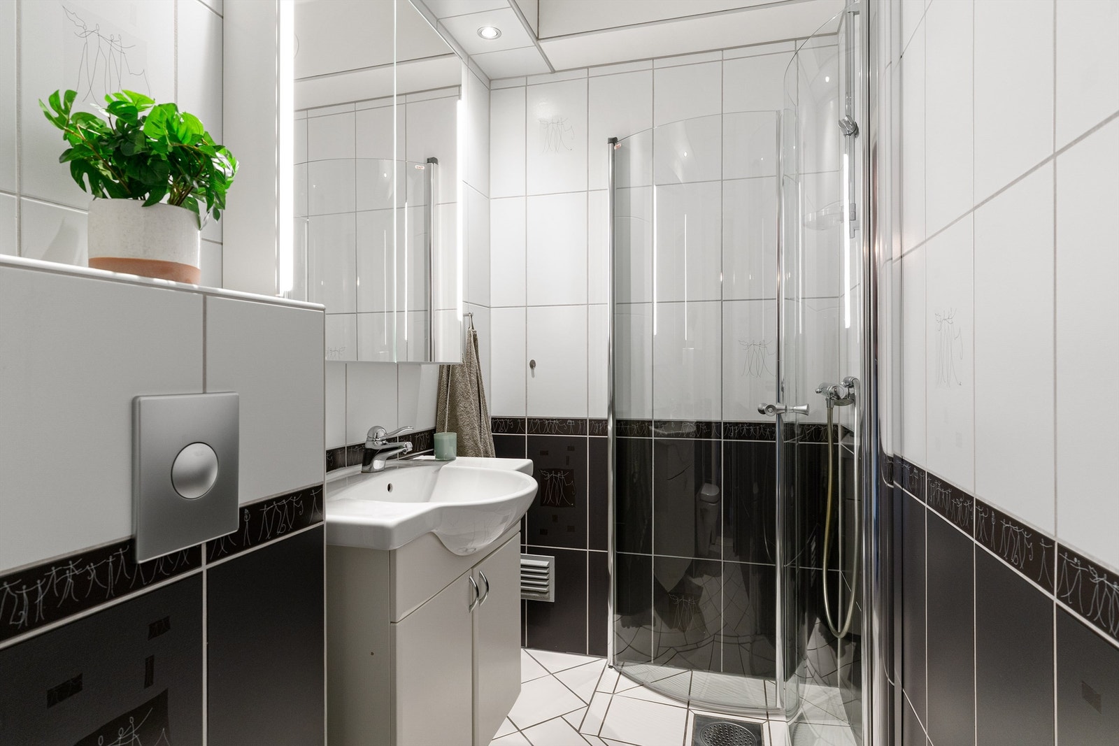 Badet er flislagt og har elektrisk gulvvarme for ekstra komfort. Innredningen består av vegghengt servantskap med servant, samt et praktisk speilskap med belysning over. Galleribilde