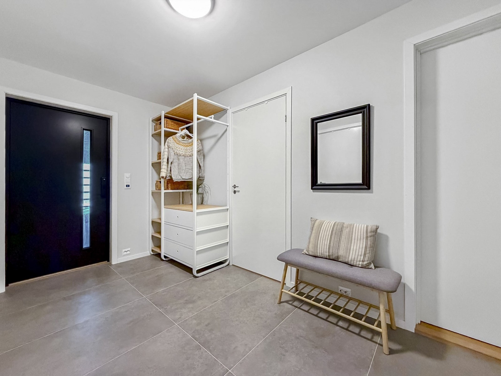 Romslig gang med lyse flater og store fliser på gulv med varmekabler. Galleribilde