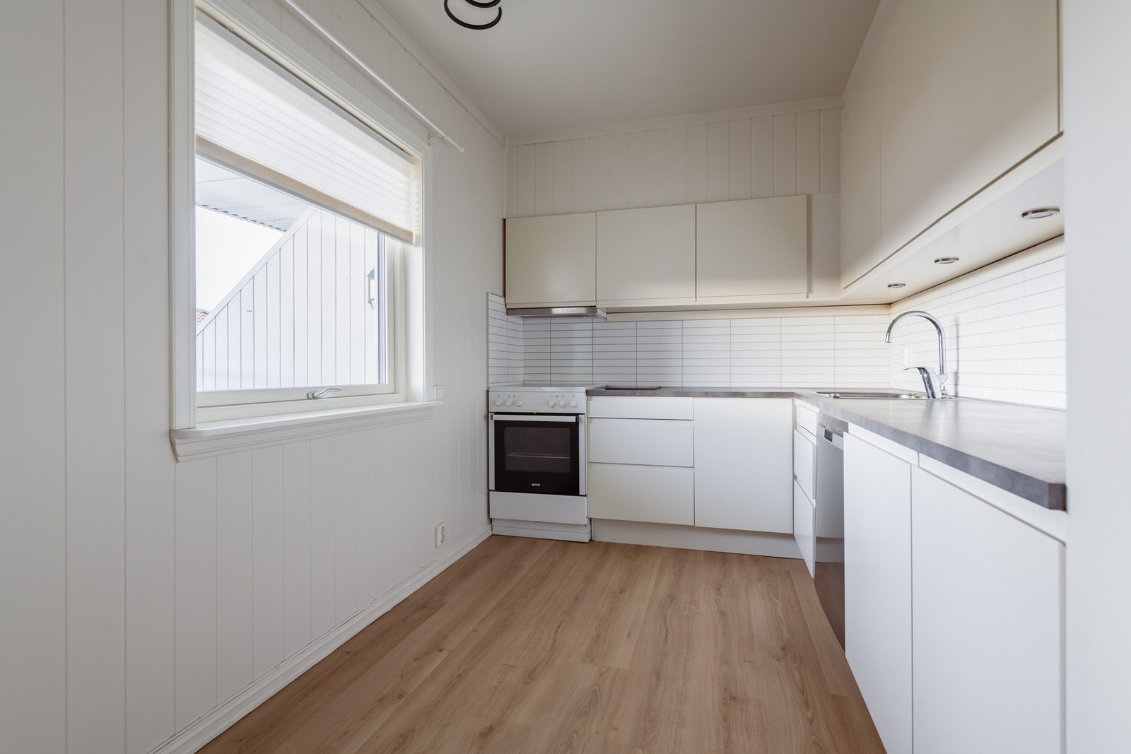 Lyst og pent kjøkken med slett innredning Galleribilde