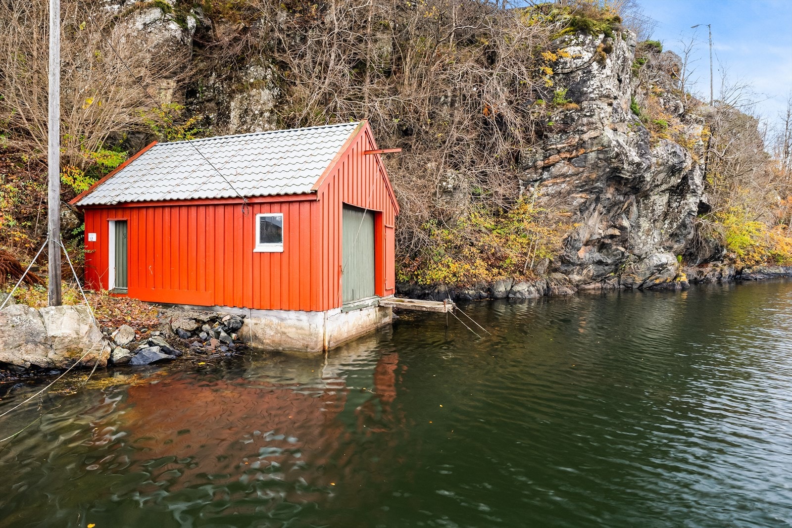 Naustet er utstyrt med skyvbare naustdører som gir enkel adkomst og skaper en åpen og maritim atmosfære. Galleribilde