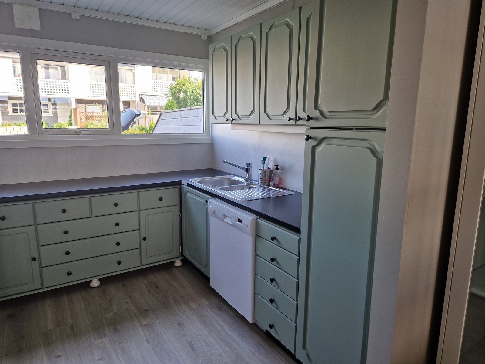 Kjøkkenet har godt med skap og benkeplass Galleribilde