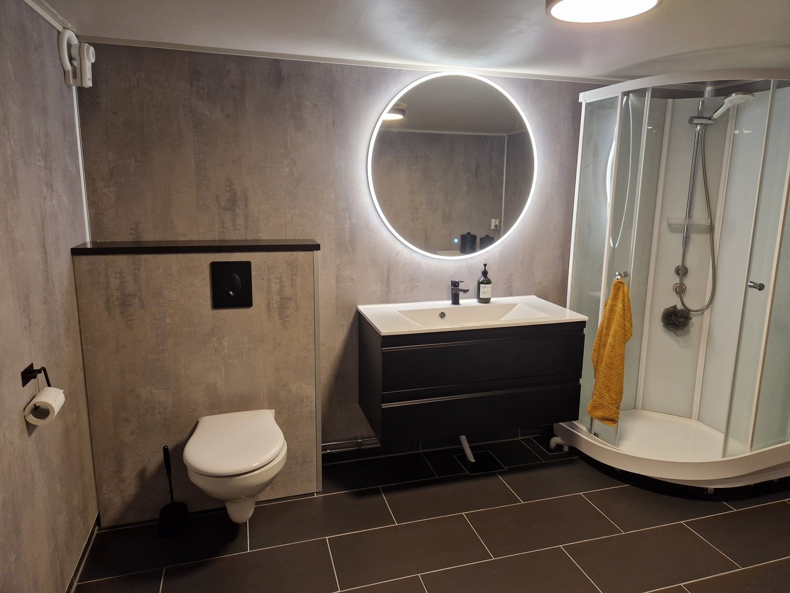 Badet er romslig og har vegghengt toalett og dusjkabinett Galleribilde