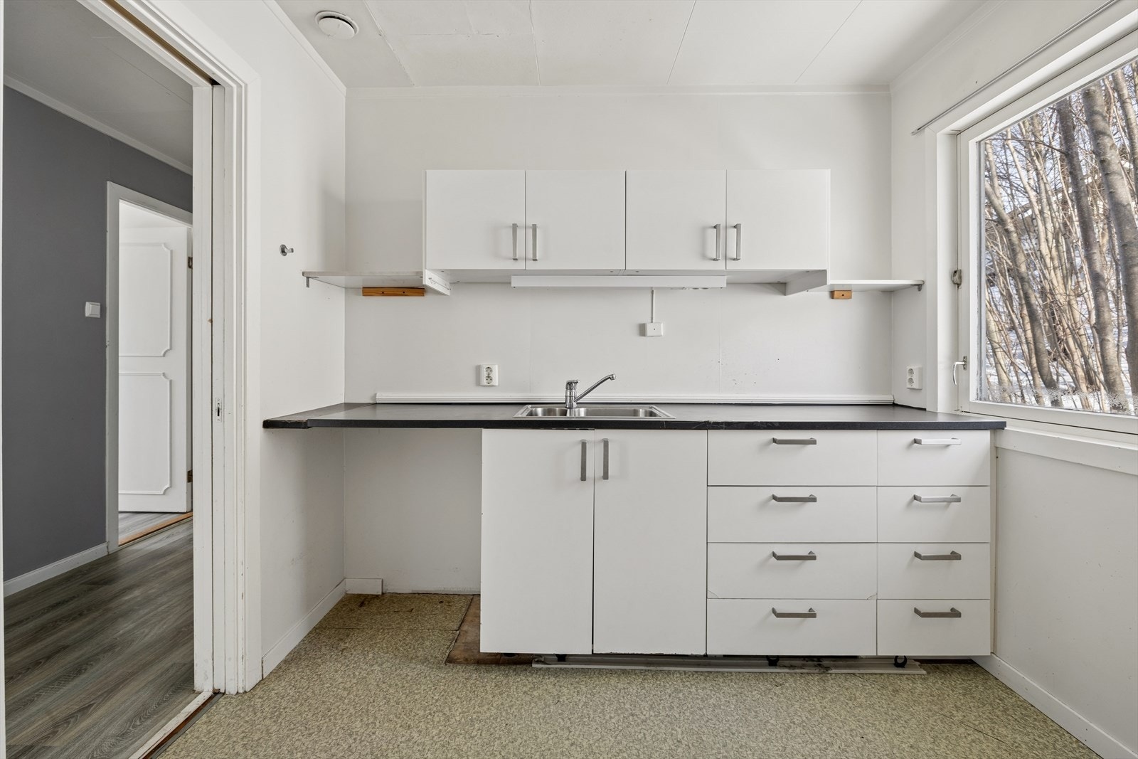 Romslig kjøkken med stort vindu som slipper inn rikelig med naturlig lys inn i rommet. Galleribilde