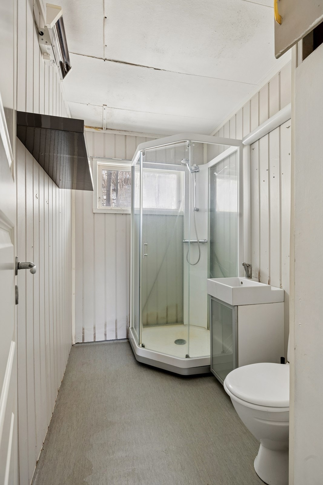 Baderom med dusjkabinett, servant og toalett. Galleribilde