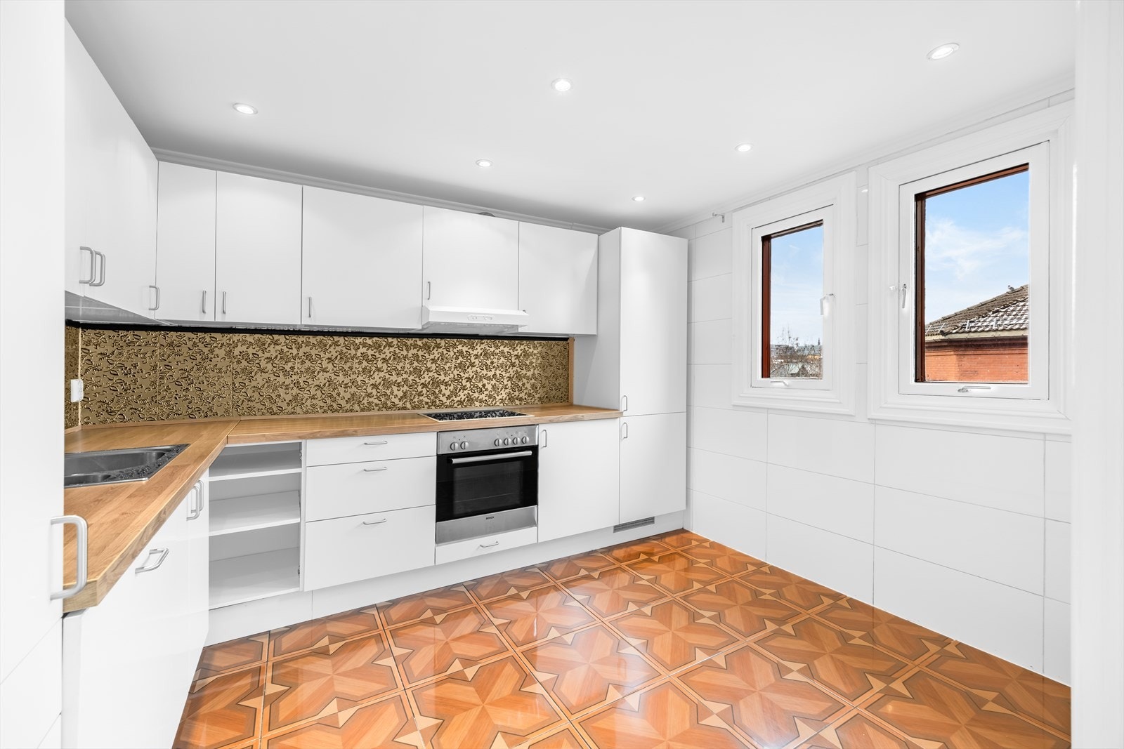 Kjøkkenet har innredning med glatte fronter. Det er kjøl/fryseskap, oppvaskmaskin, nedfelt platetopp og innebygget stekeovn. Benkeplaten er av laminat. Det er kjøkkenventilator med kullfilter. Galleribilde