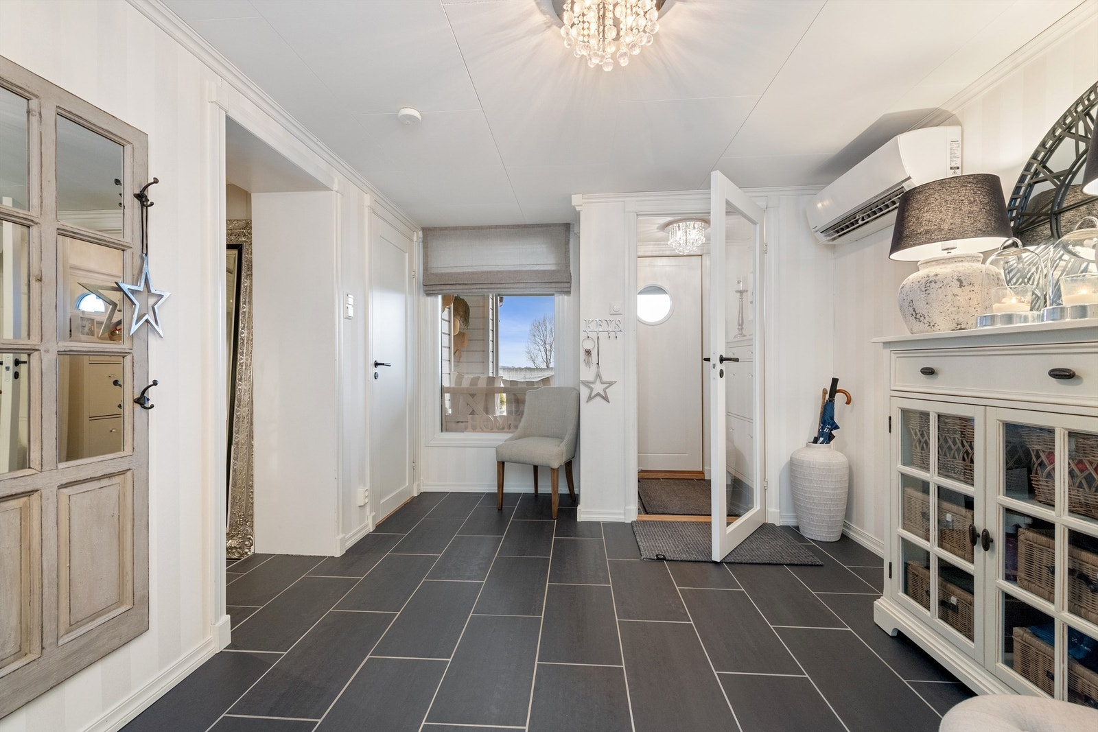 Den romslige hallen i underetasjen har flislagt gulv med gulvvarme Galleribilde