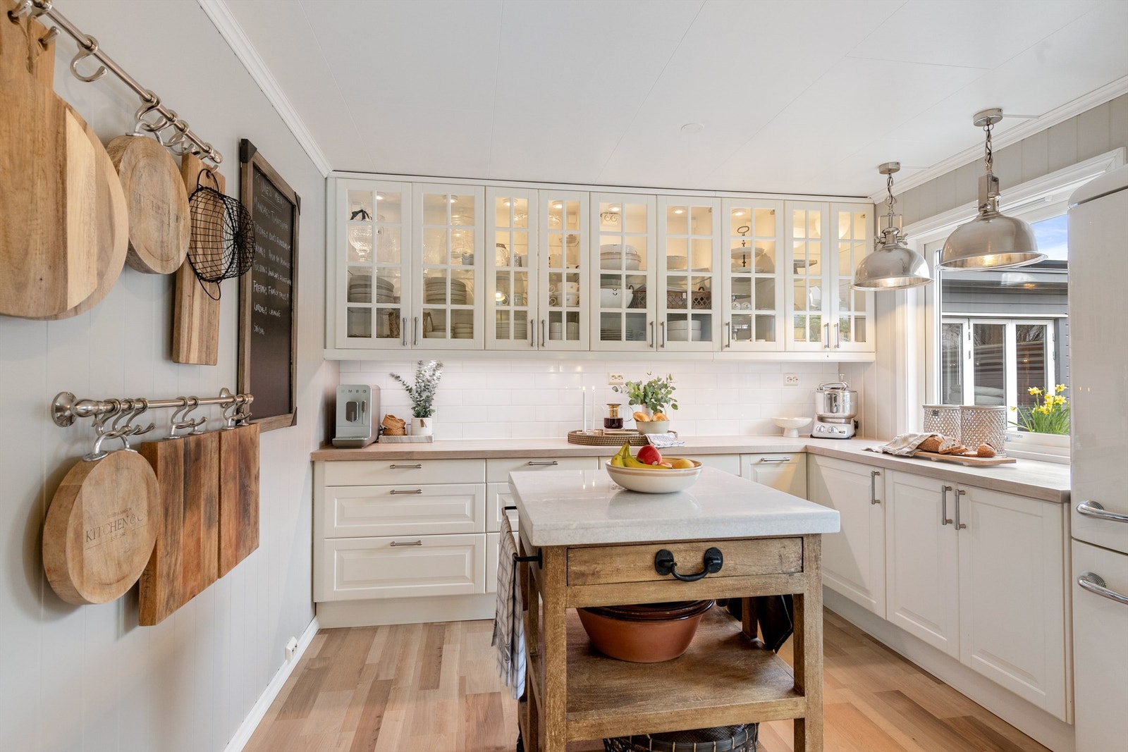 IKEA-kjøkkeninnredning fra 2006/2012 med profilerte fronter og vitrineskap med belysning Galleribilde