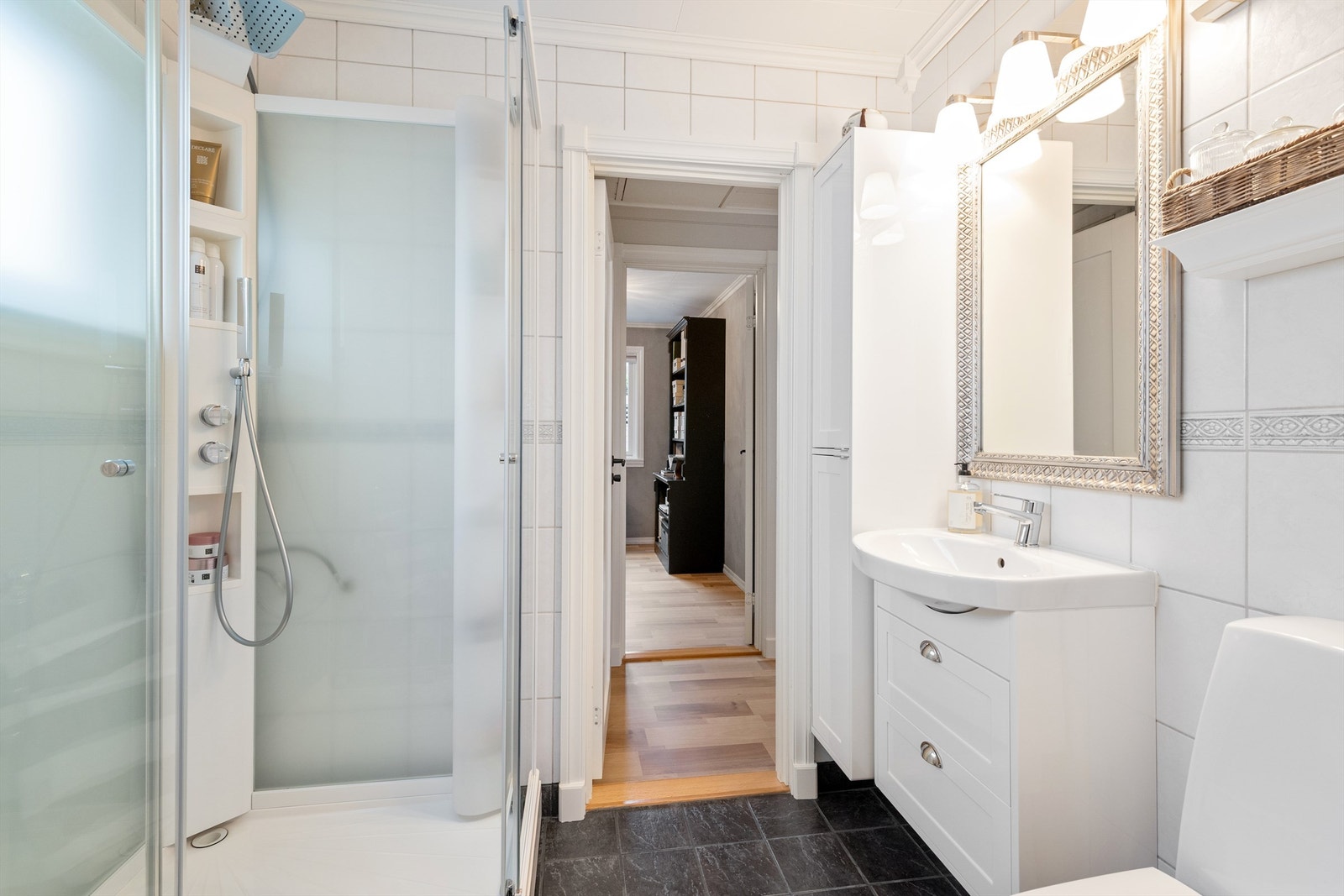 Badet er utstyrt med dusjkabinett, gulvstående toalett og har gulvvarme for ekstra komfort Galleribilde