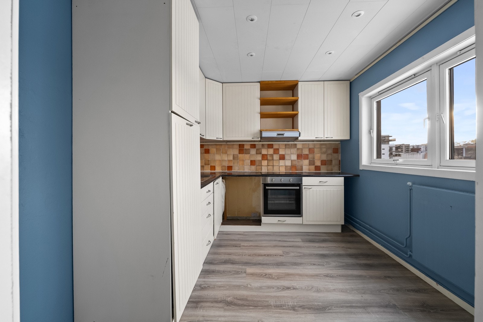 Elektrisk ventilator er montert over kokesonen, og oppvarming skjer via radiator under de store vinduene. Galleribilde