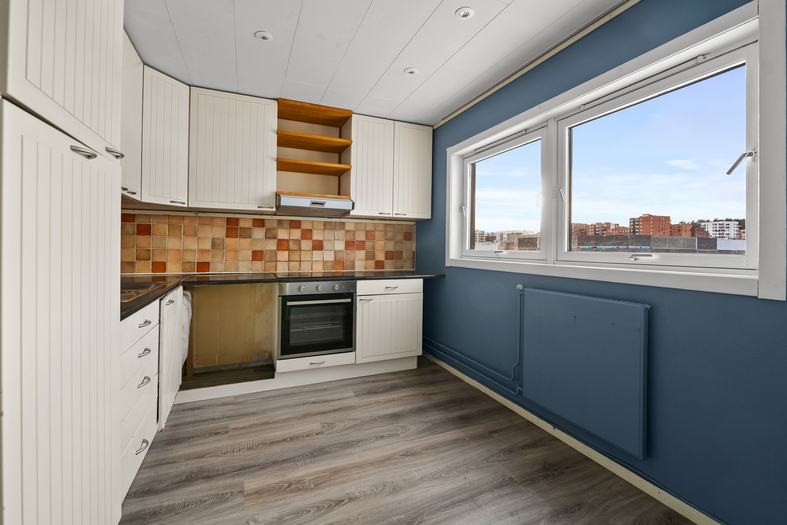 Kjøkkenet er et separat eldre Ikea-kjøkken med praktisk vinkelløsning som gir rikelig benke- og arbeidsplass. Innredningen har profilerte fronter, laminert benkeplate og nedfelt vaskekum. Galleribilde