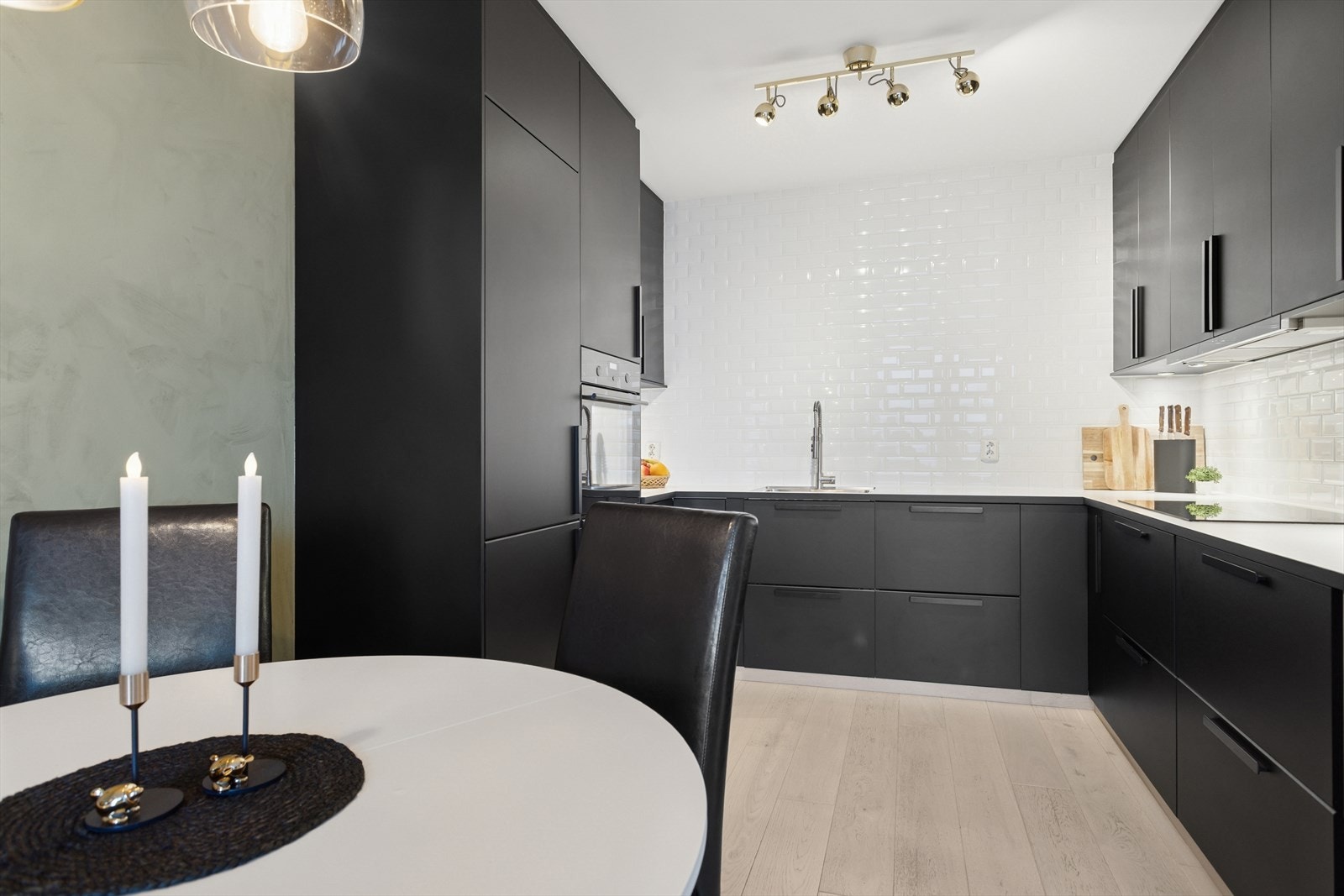 Kjøkkeninnredning med slette fronter som gir et rent og tidløst uttrykk, mens den laminerte benkeplaten gir god arbeidsflate og er enkel å vedlikeholde. Veggen er flislagt, noe som både beskytter og tilfører et elegant preg til rommet. Galleribilde