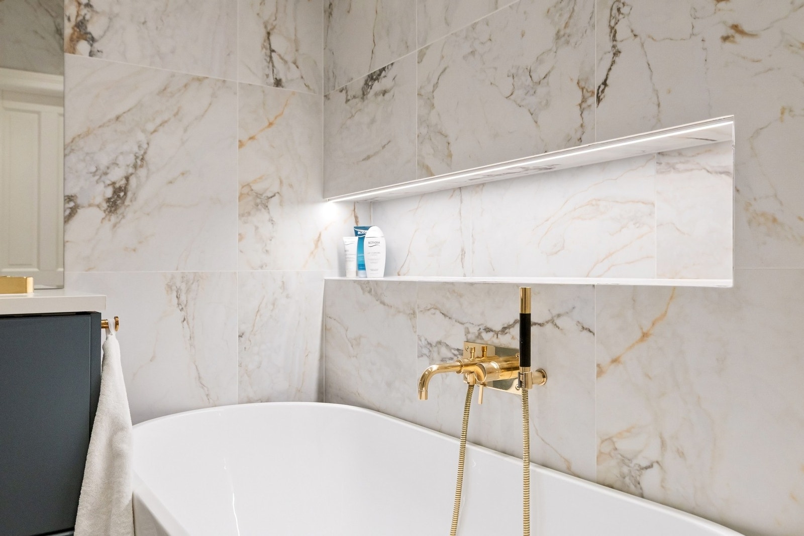 Videre inneholder baderommet servantskap med glatte fronter, servant, speil på vegg, veggmontert klosett, samt nydelig frittstående badekar. Galleribilde