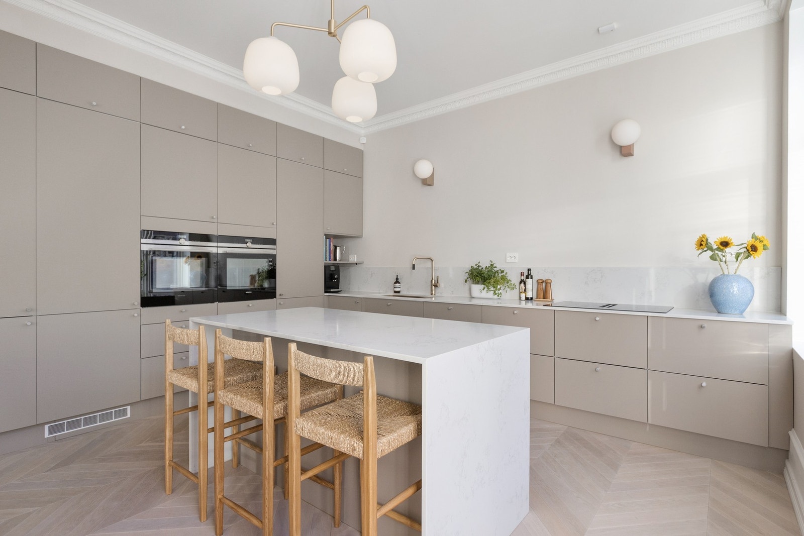 Kjøkkeninnredningen er utstyrt med glatte beige fronter. Galleribilde