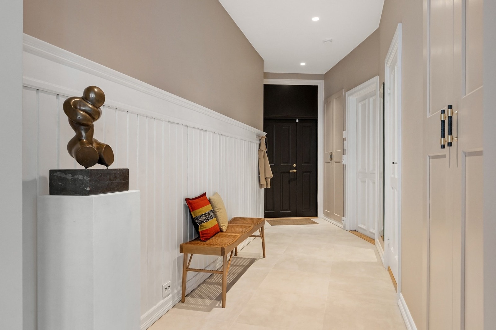 Lekre fliser på gulv, overflater malt i moderne farger, behagelig gulvvarme og plass til oppbevaring i praktiske plassbygde skap i en lekker utforming. Galleribilde