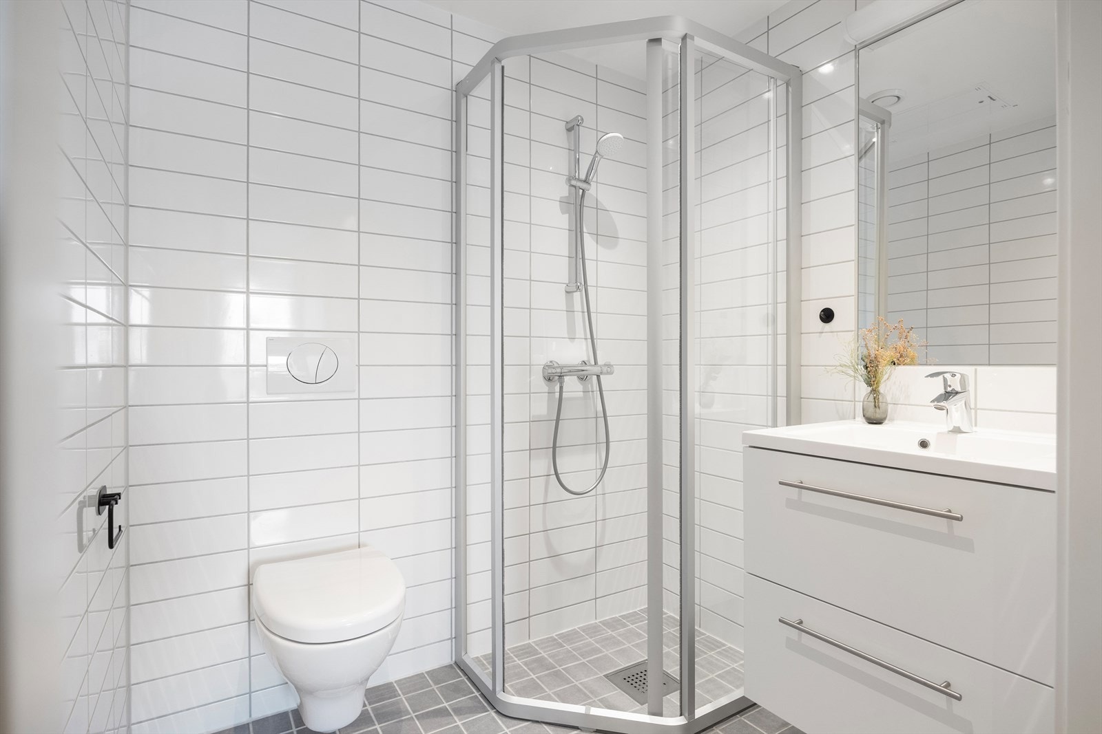 Baderom 2: Flott flislagt baderom med vannbåren gulvvarme og downlights i himlingen. Badet er utstyrt med vegghengt toalett, dusjhjørne med herdet glassvegg/-dør, servant med skap, speil og belysning. Galleribilde