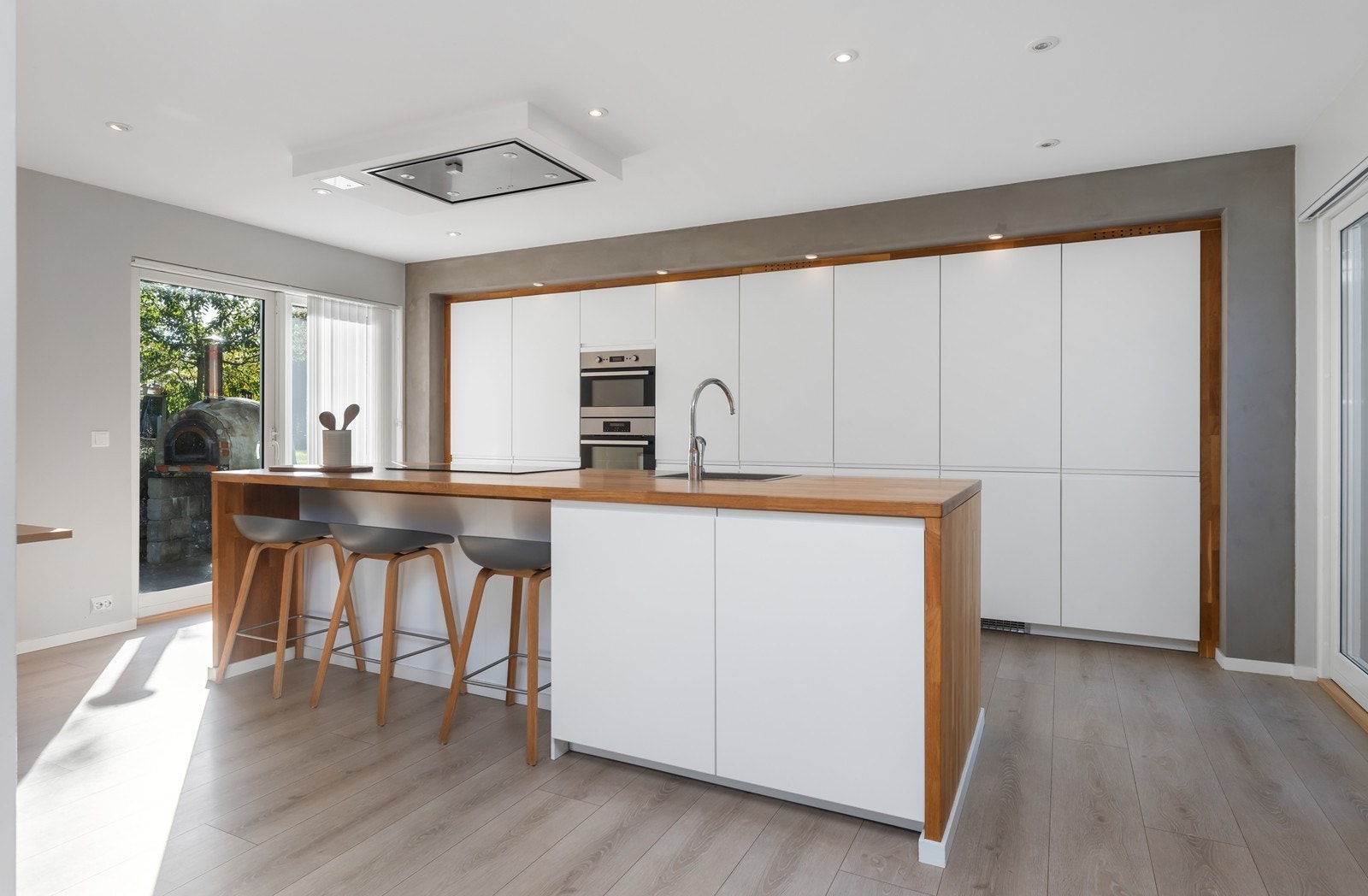 Moderne og stilrent kjøkken med integrerte hvitevarer, rene linjer og praktisk kjøkkenøy - perfekt for både hverdagsbruk og sosiale sammenkomster. Galleribilde