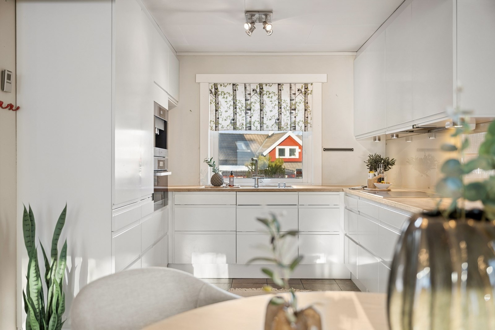 Det er belysning under overskapene og glassplater på deler av veggen over benken. Galleribilde