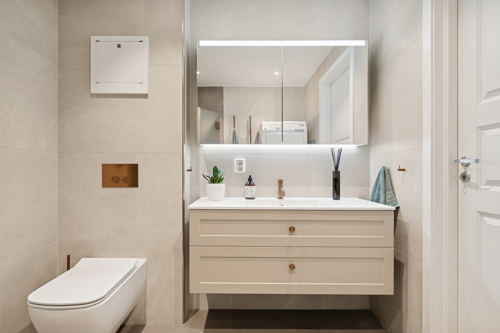 Innredningen består av baderomsmøbel med heldekkende servant, overskap med speil og belysning, vegghengt toalett og dusjkabinett. Det er opplegg for vaskemaskin. Galleribilde