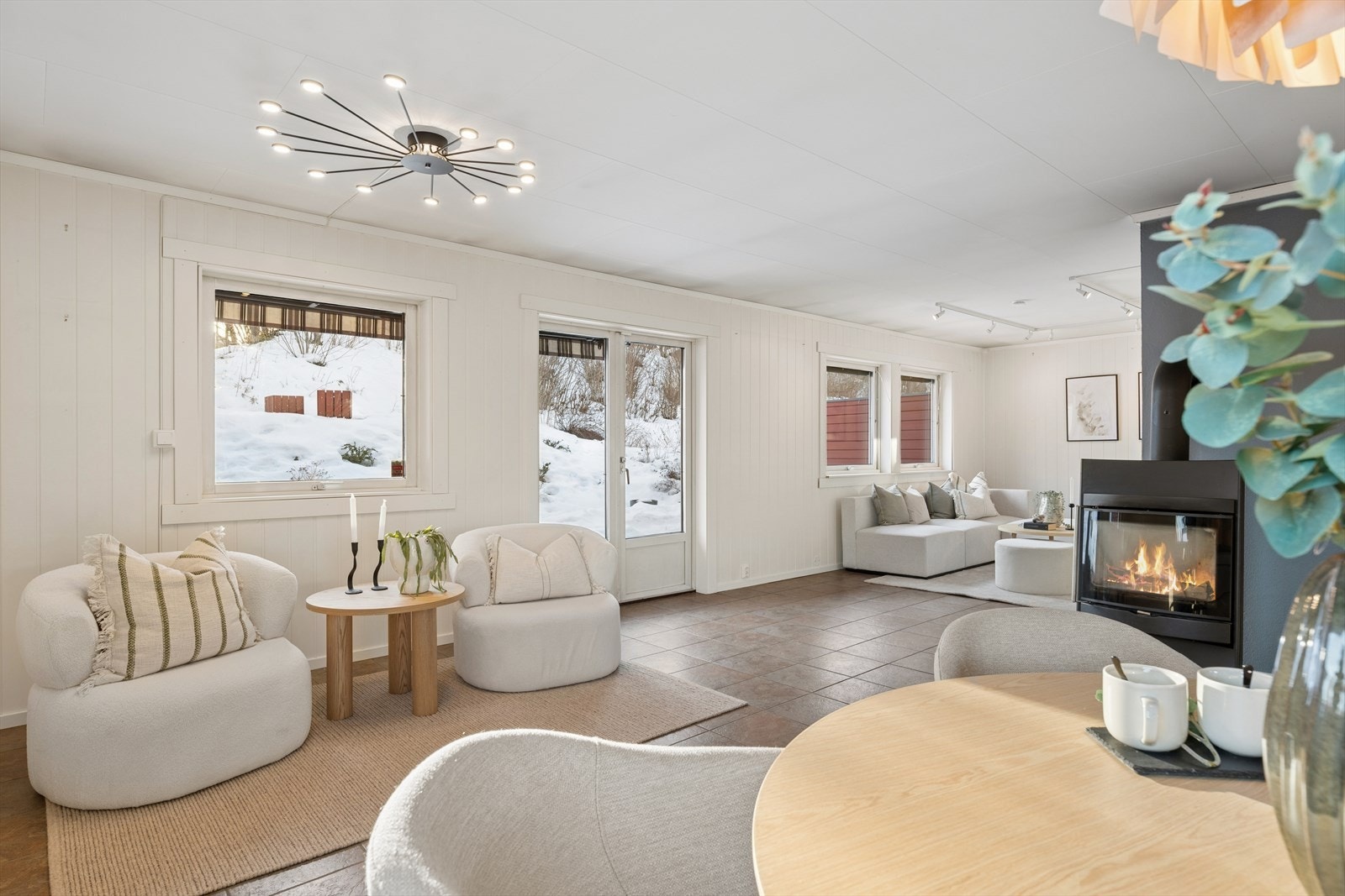 Stuen har store vindusflater som slipper inn godt med naturlig lys og gir rommet en lys og luftig følelse. Galleribilde