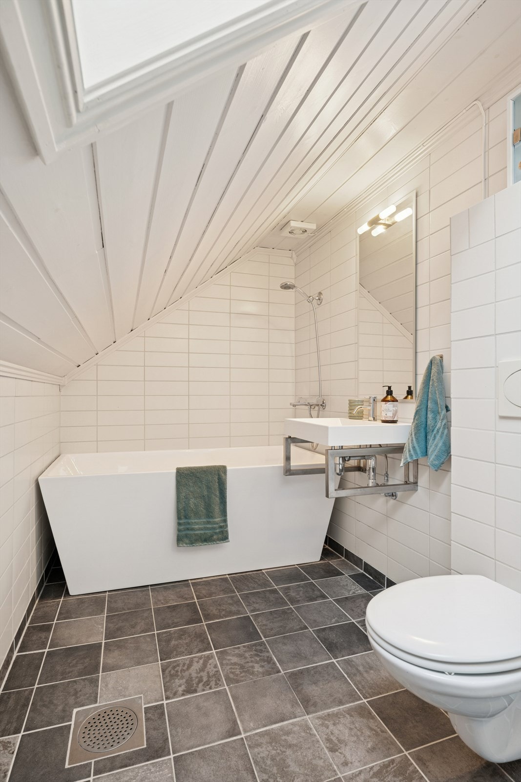 Rommet er innredet med servant, badekar og vegghengt toalett. Galleribilde