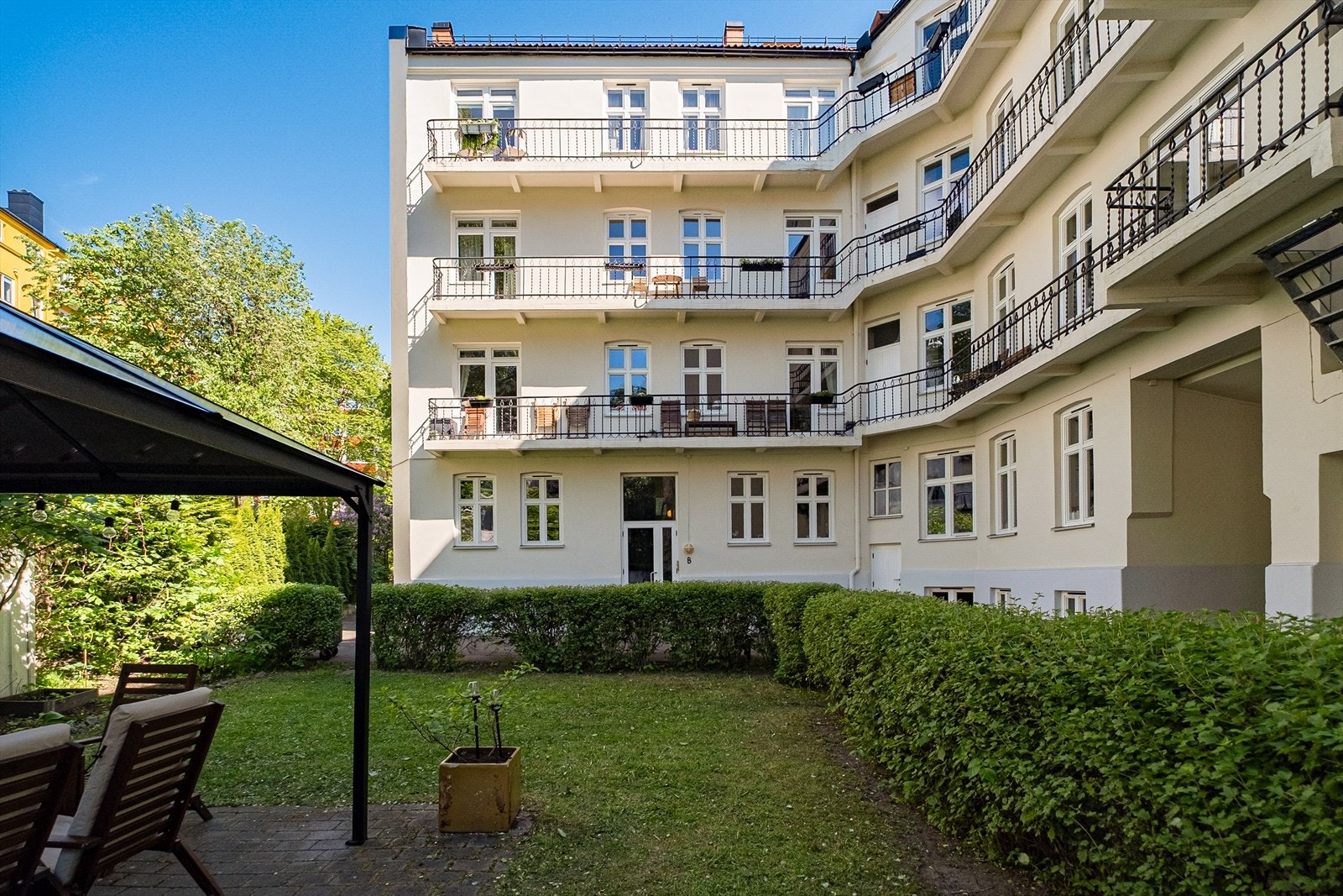 Bakgården byr på en hyggelig kombinasjon av grønne trær, sitteplasser og skjerming fra byens puls. Galleribilde