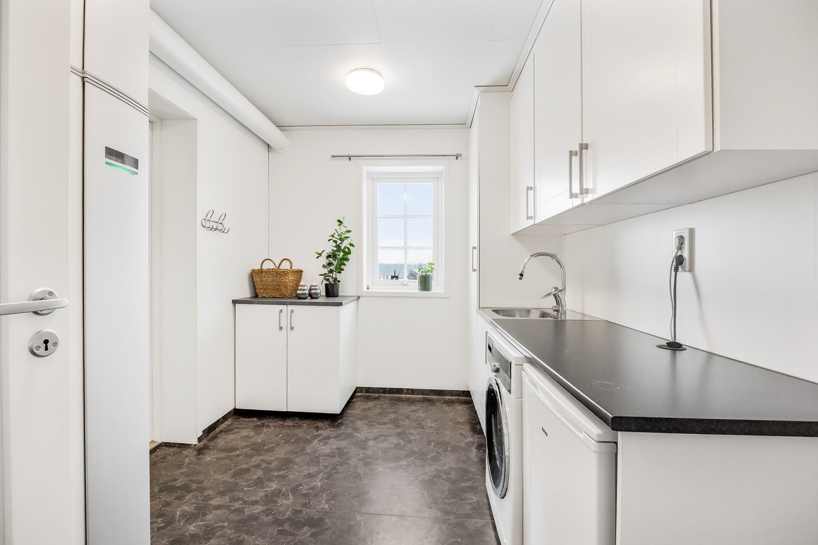 Separat vaskerom med god benkeplass og opplegg for vaskemaskin og tørketrommel. Galleribilde