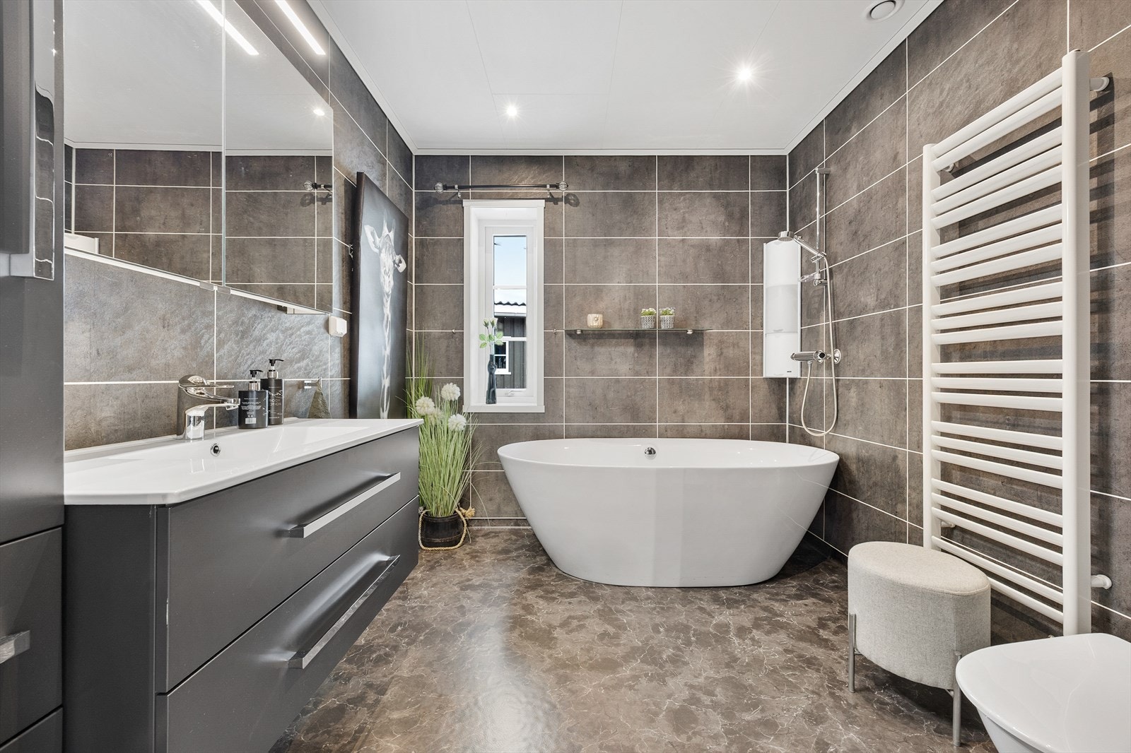 Hovedbadet har et delikat preg med mørke overflater og tidløs innredning. Galleribilde