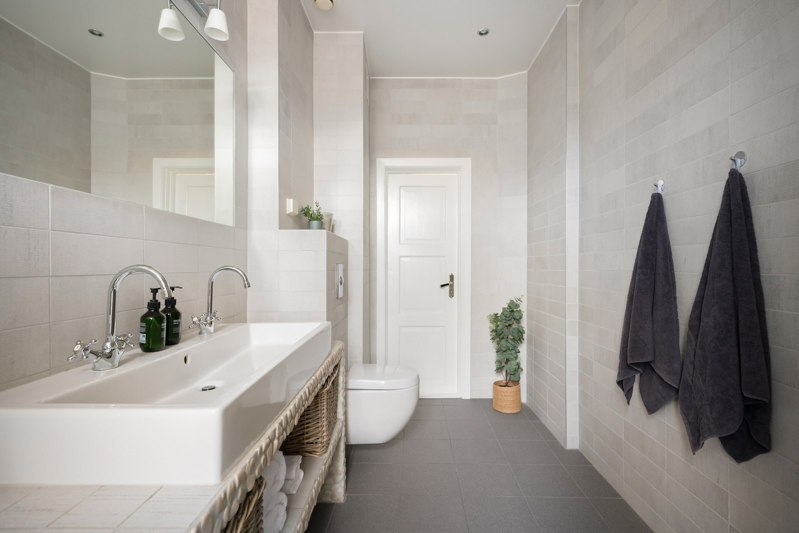 Badet består av flislagte vegger, flislagt gulv med varmekabler og malt himling. Galleribilde