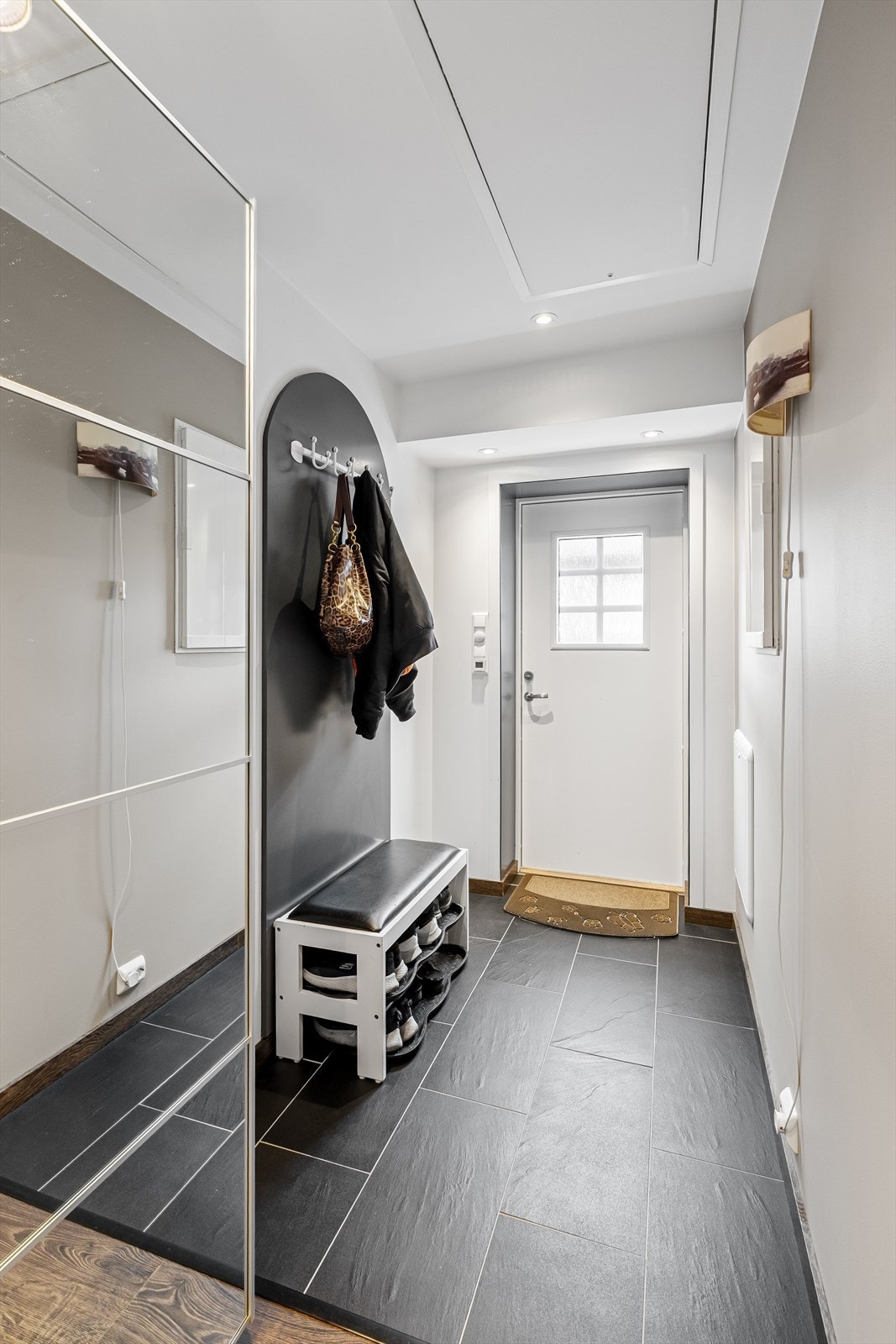 Idet du trer over dørkarmen, blir du møtt av en lys og innbydende gang med god plass til oppbevaring av sko og yttertøy. Galleribilde