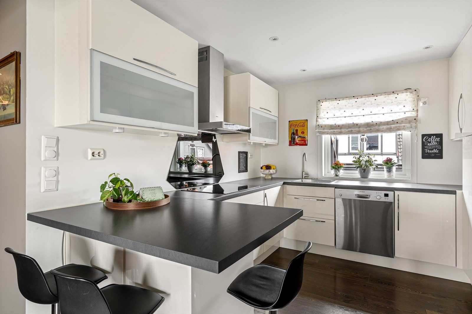 Kjøkkenet er stilrent med hvite, slette fronter og benkeplate i sort utførelse som gir en fin kontrast. Galleribilde