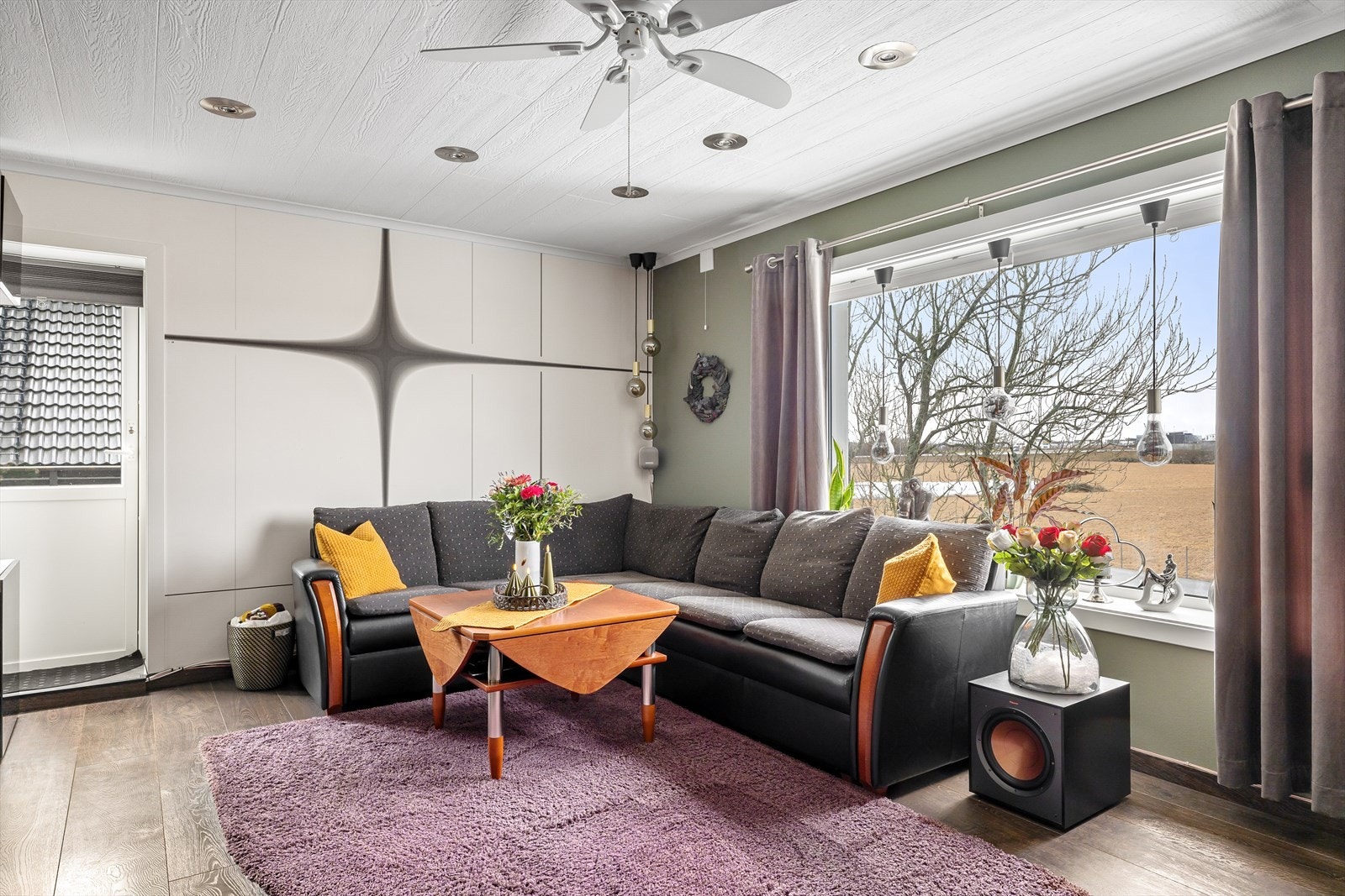 Gangen leder videre inn til en lys og romslig stue med store vindusflater som slipper inn rikelig med dagslys. Galleribilde