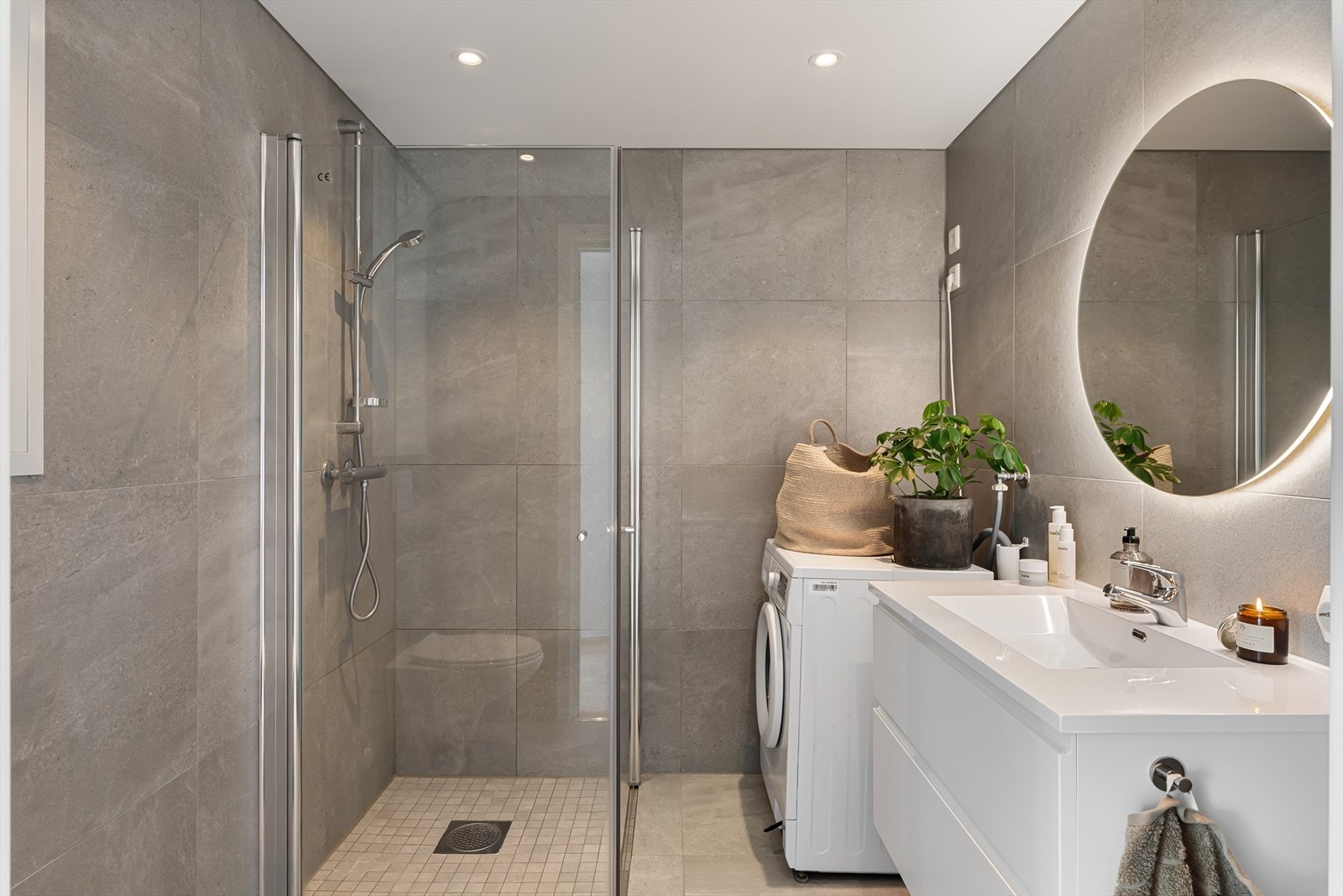 Lekkert helfliset bad med 60x60 fliser som inneholder vegghengt wc, dusjhjørne og varme i gulv for ekstra komfort. Galleribilde