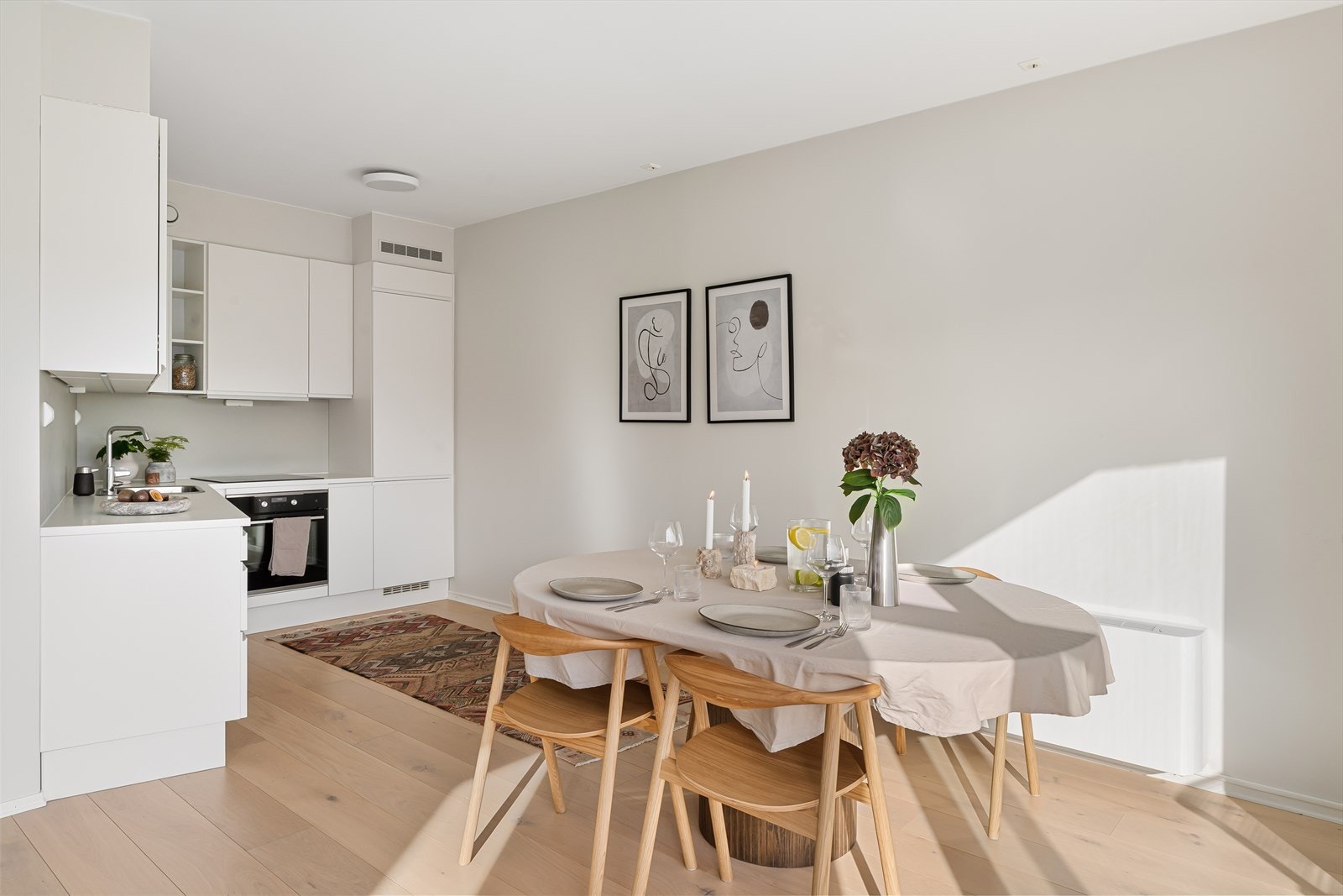 Flott kjøkken med pen kjøkkeninnredning i hvit utførelse og integrerte hvitevarer. Galleribilde