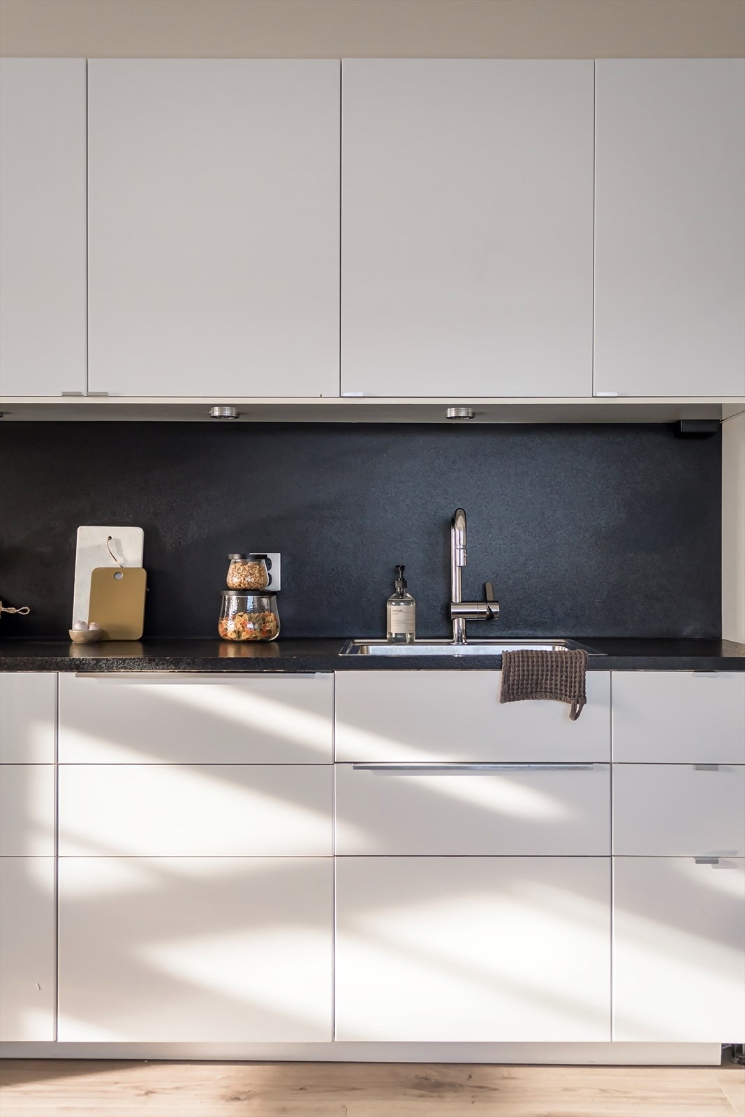 Stilren innredning med hvite fronter og laminert benkeplate. Galleribilde