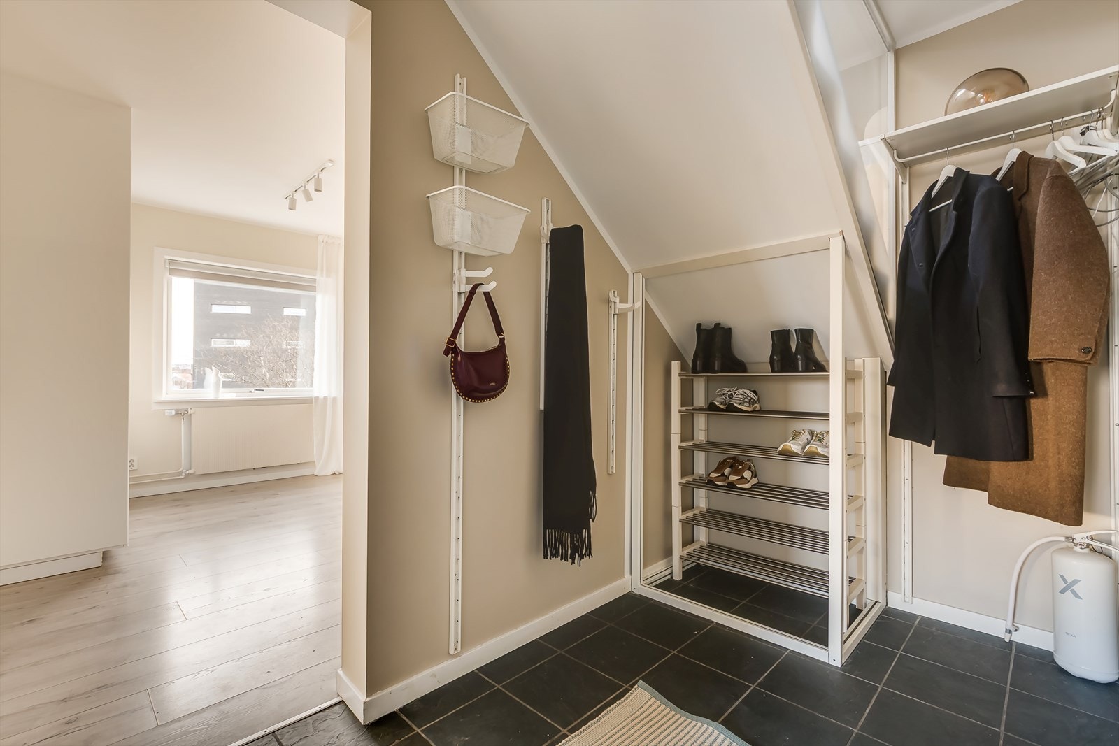 Innbydende entré med praktisk flislagt gulv, og god plass til oppheng av yttertøy og plassering av sko. Galleribilde