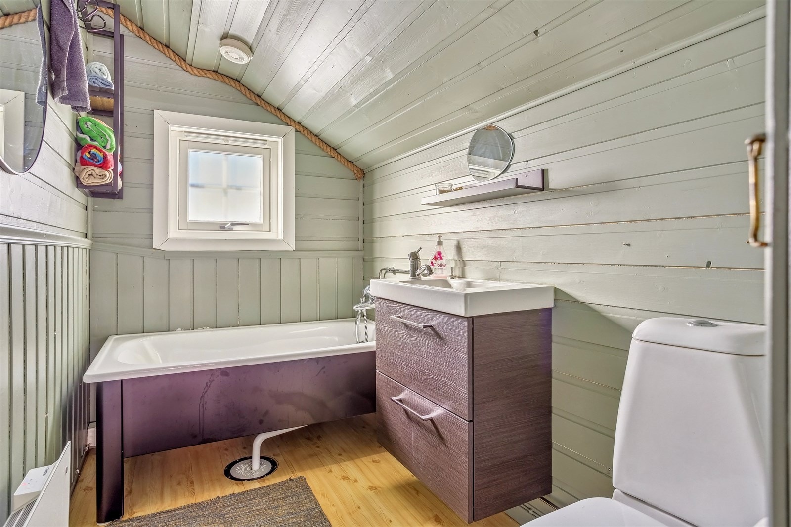 Badet er innredet med nytt badekar, wc og servant med skap under Galleribilde