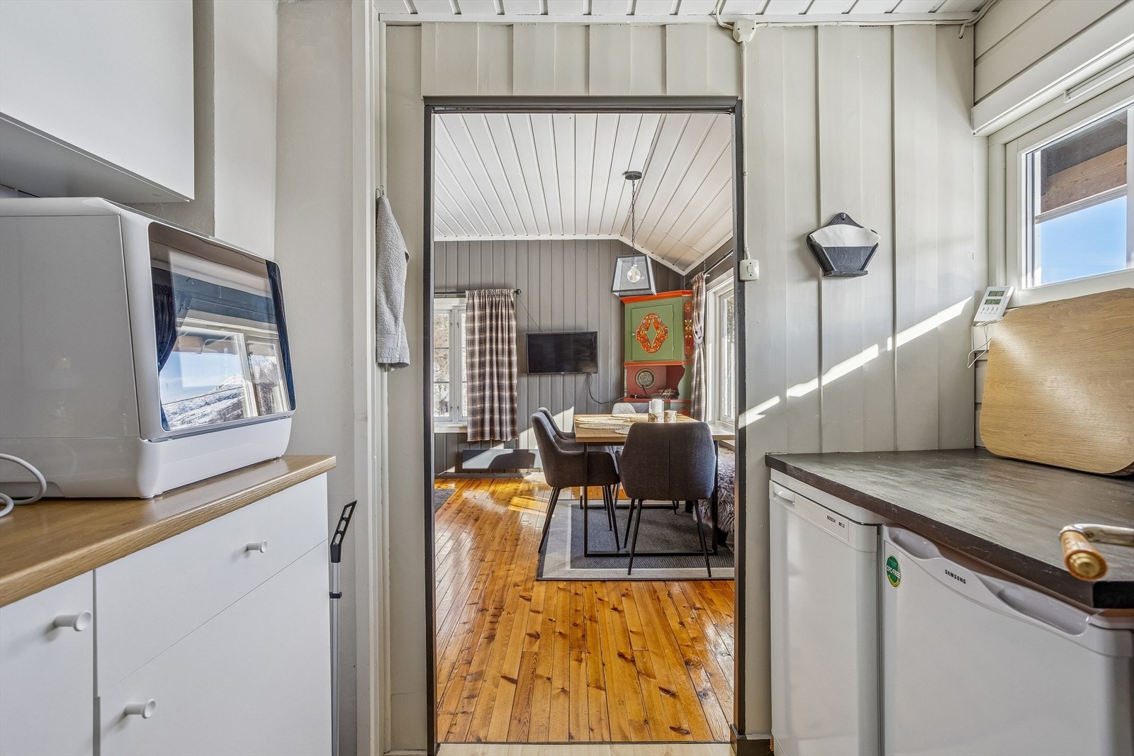 Praktisk lite hyttekjøkken med kjøle- og fryseskap og hybelkomfyr Galleribilde